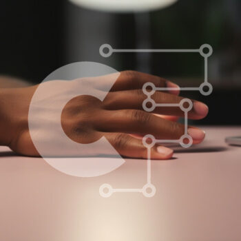 Intra Συλλεκτικό Ξύλινο Παζλ Plywood  4mm - Κοντινό πλάνο ενός χεριού σε ένα ροζ τραπέζι δίπλα σε ένα φορητό υπολογιστή Σε Ξύλινο Κουτί - Διαστάσεις Puzzle: 10x10 cm – 25 κομμάτια - Image 1